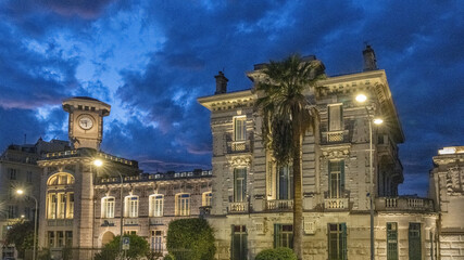 Le lycée Massena à Nice illuminé le soir à l'heure bleue avec des nuages menaçants