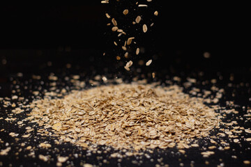 Falling oatmeal on wooden background