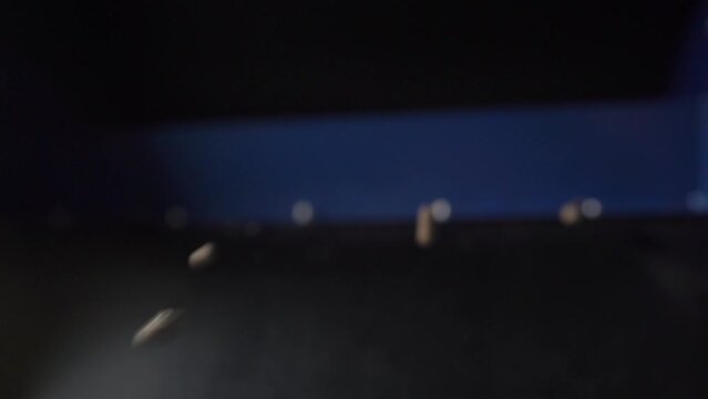 Wood fuel pellets fall on cells of delivering conveyor belt