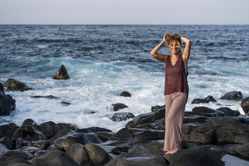 smiling woman posing to camera on sea coast