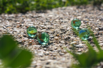 Child playing with marbles on yhe sidewalk. old-fashioned toys still in use today.