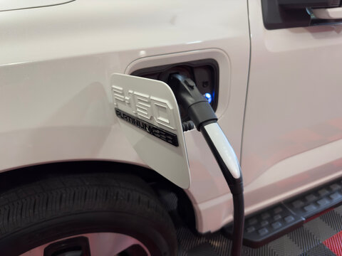 White Ford 150 Lightning Electric Truck Platinum Plugged In and Charging