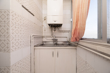 Old sink and natural gas heater with white painted copper pipes