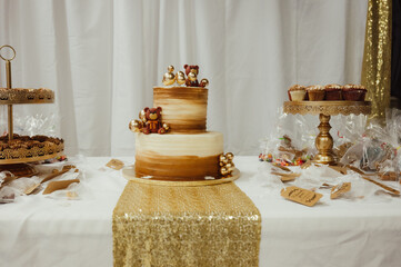 a decorated golden brown two tiered cake decorated with bears sits on a table