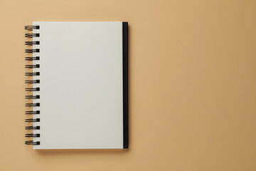 Blank notebook on beige background, top view. Space for text