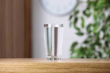 Glass of pure water on wooden table indoors