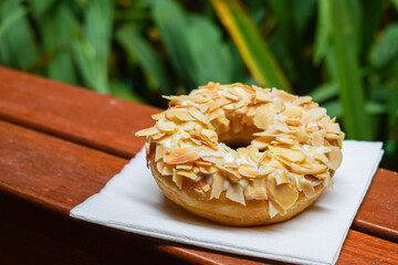 assorted colorful donuts, with assorted toppings of chocolate, nuts, almonds, cheese, strawberries, placed alone or stacked on top
