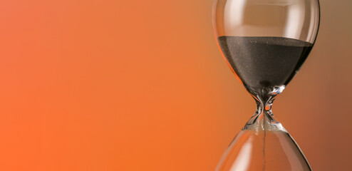 Hourglass on orange background with space for text, closeup