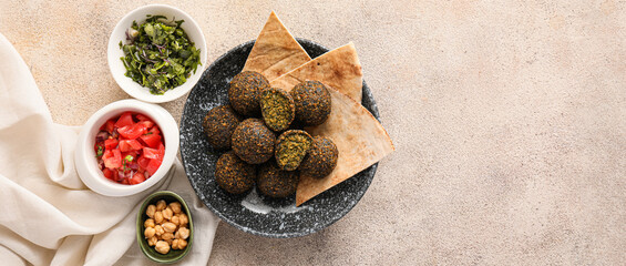 Plate with tasty falafel balls, pitas and ingredients on light background with space for text