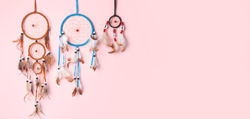 Beautiful dream catchers on pink background with space for text