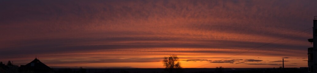 Obraz na płótnie Canvas Landscape at sunset. Tragic gloomy sky. Panorama. Crimson twilight.