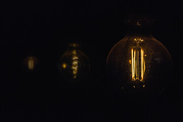 Classic vintage retro incandescent Edison light bulb lamps hanging in a restaurant or cafe bar,...