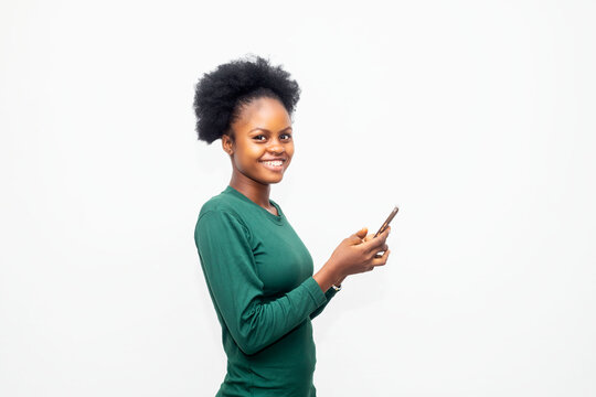 image of a young african American woman holding her mobile phone shopping online checking content online
