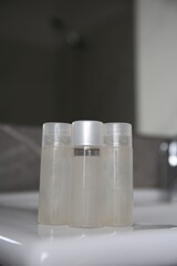 Bottles of shower gel on sink in bathroom