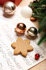 Note sheets with Christmas decor and cookie on beige background, closeup