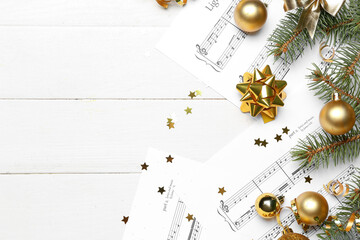 Note sheets with Christmas balls, fir branches and serpentine on white wooden background