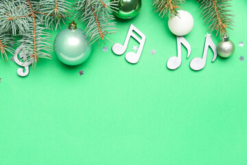 Note signs with Christmas balls and fir branches on green background