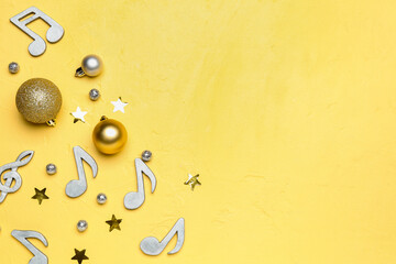 Composition with note signs and Christmas balls on yellow background