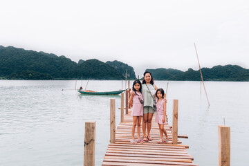Obraz premium My Traveler family on wooden bridge in the sea and mountain at Nakhon si thammarat Thailand