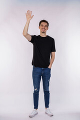 Portrait of friendly cheerful man in black t-shirt and jeans saying hi, welcome person as waving hand