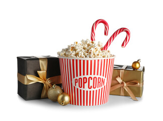 Bucket of popcorn with candy canes, Christmas balls and presents on white background