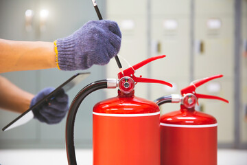 Fire extinguisher has hand engineer inspection checking pressure gauges to prepare fire equipment...