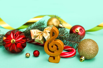 Treble clef with Christmas branches and decor on green background, closeup