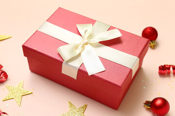 Christmas gift and balls on color background, closeup