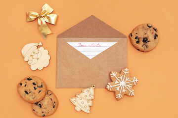 Letter to Santa with cookies and Christmas decor on orange background