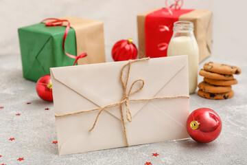 Letter to Santa with Christmas ball on light background, closeup