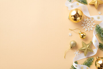 New Year concept. Top view photo of golden baubles star ornaments pine branches white curly ribbon and snowflakes on isolated beige background with copyspace