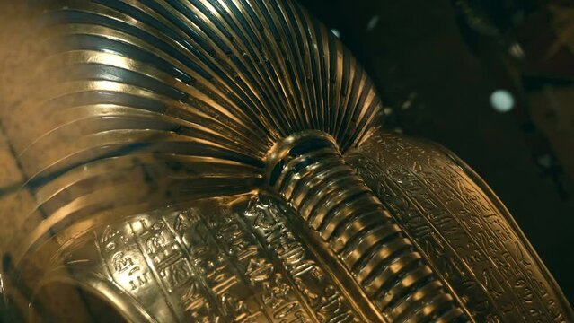 The back side of the golden mask of Tutankhamen, with many hieroglyphs, signs and symbols - one of the exhibits of Tutankhamun's tomb, a symbol of Ancient Egypt. Shot in motion. Closeup