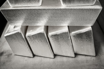 Stack of industrial silver ingots at bright light in storage