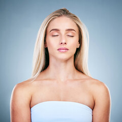 Beauty, skincare and eyes closed with a model woman in studio on a gray background for wellness or...