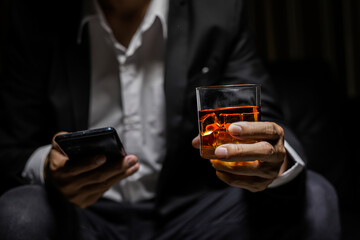 Closeup businessmen holding a glass of whiskey