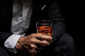 Closeup businessmen holding a glass of whiskey