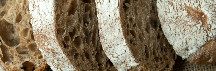 Sourdough bread with crispy crust on wooden shelf. Bakery goods