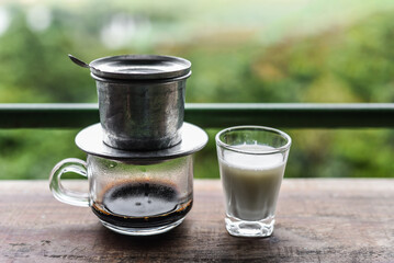 Vietnamese traditional coffee with milk on wooden table