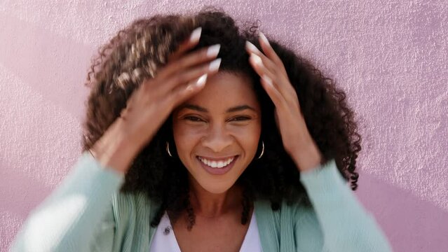 Beauty, hair care and natural kinky afro with black woman styling curls, proud and happy against a purple wall in an urban city. Portrait of a positive African American feeling proud of hair
