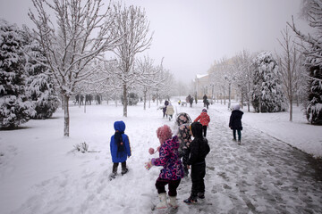 The children are playing outside in the snow.