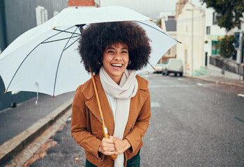 Rain, umbrella and city with a walking black woman in the street during a cold or wet winter day. Water, insurance and cover with a young afro female outdoor for a walk in an urban town road - obrazy, fototapety, plakaty