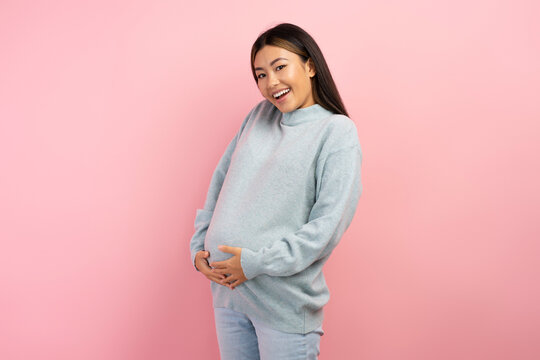 Image of a beautiful young pregnant asian woman smiling to the camera