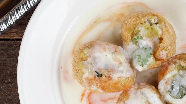 Tadeonal subcontinental Indian street snack food chickpeas potato Dahi Puri Chaat pani puri fuska  rotate zoom out 