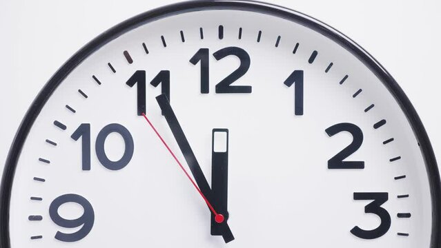 part of a round white wall clock with a red second hand on a white background. twelve o'clock