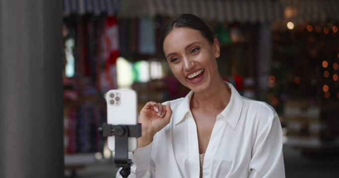 Horizontal video shot of a beautiful dark-haired Caucasian woman having a video conference on her smartphone, mounted on tripod. Online communication accross the distance. Online meeting
