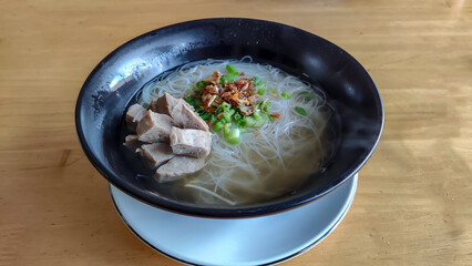Meatball noodles in a black bowl