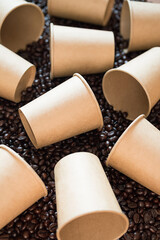 Mock up disposable coffee cups lying on coffee beans. Some empty paper coffee cups.