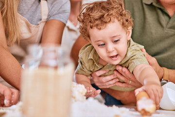 Love, parents and baby with cake for birthday party or celebration together. Adorable child, mother and father celebrate happiness and kids hands playing with food or desert on table in family home