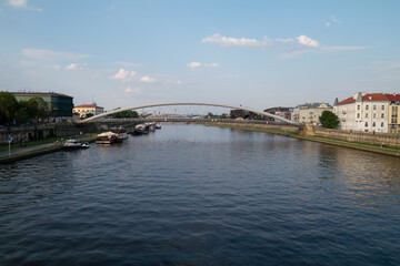 Vistula River (Wisła) in Krakow, Poland. Vistulan Boulevards with Father Bernatek’s pedestrian and bicycle bridge (Kładka Ojca Bernatka Kraków), connecting Kazimierz with Podgórze.