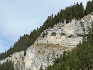 Steep stone cliffs and vertical rocks above the reservoir lake Panixersee (Lag da Pigniu) or...